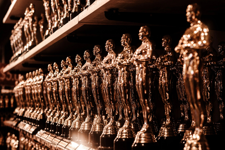 Rows of prestigious film awards trophies representing BAFTA events and luxury chauffeur transportation in London.