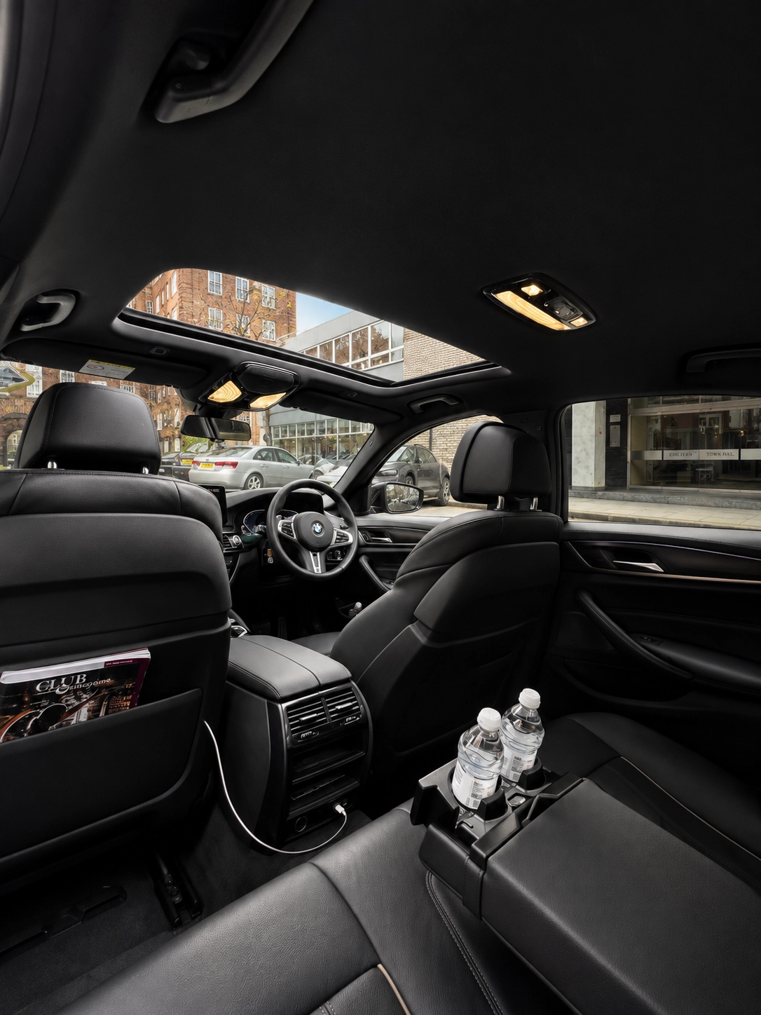 Luxury BMW chauffeur interior with leather rear seats and passenger amenities